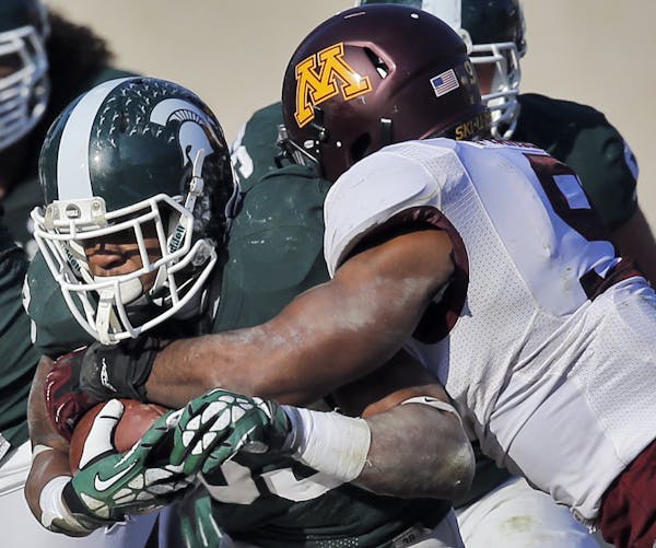 Minnesota Gophers vs. Michigan State Spartans. Michigan State won 14-3. Minnesota's Ra'Shede Hageman, right, tackled Spartan running back Jeremy Langf