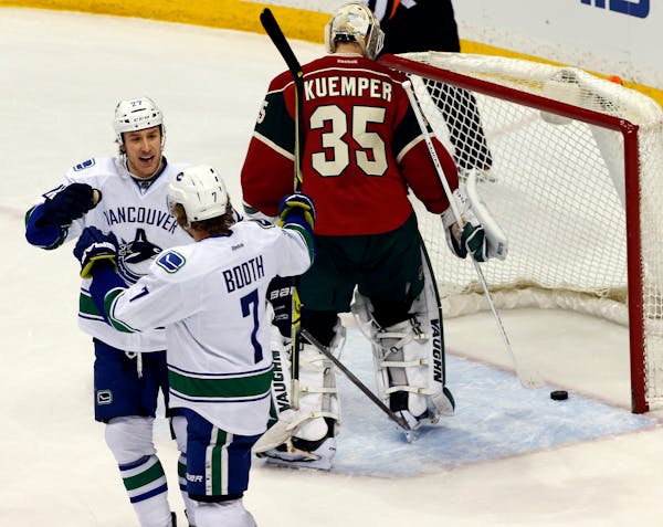 Canucks Shawn Matthias, left, congratulated David Booth (7) after he scored a goal in first period action beating Wild goalie Darcy Kuemper.