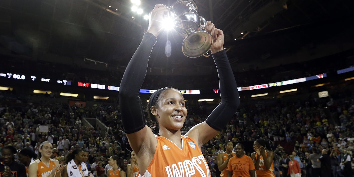 Minnesota Lynx's Maya Moore, of the Western Conference, holds up a trophy after being named most valuable player as teammates cheer behind after the WNBA All-Star basketball game Saturday, July 22, 2017, in Seattle.(AP Photo/Elaine Thompson) ORG XMIT: WAET101