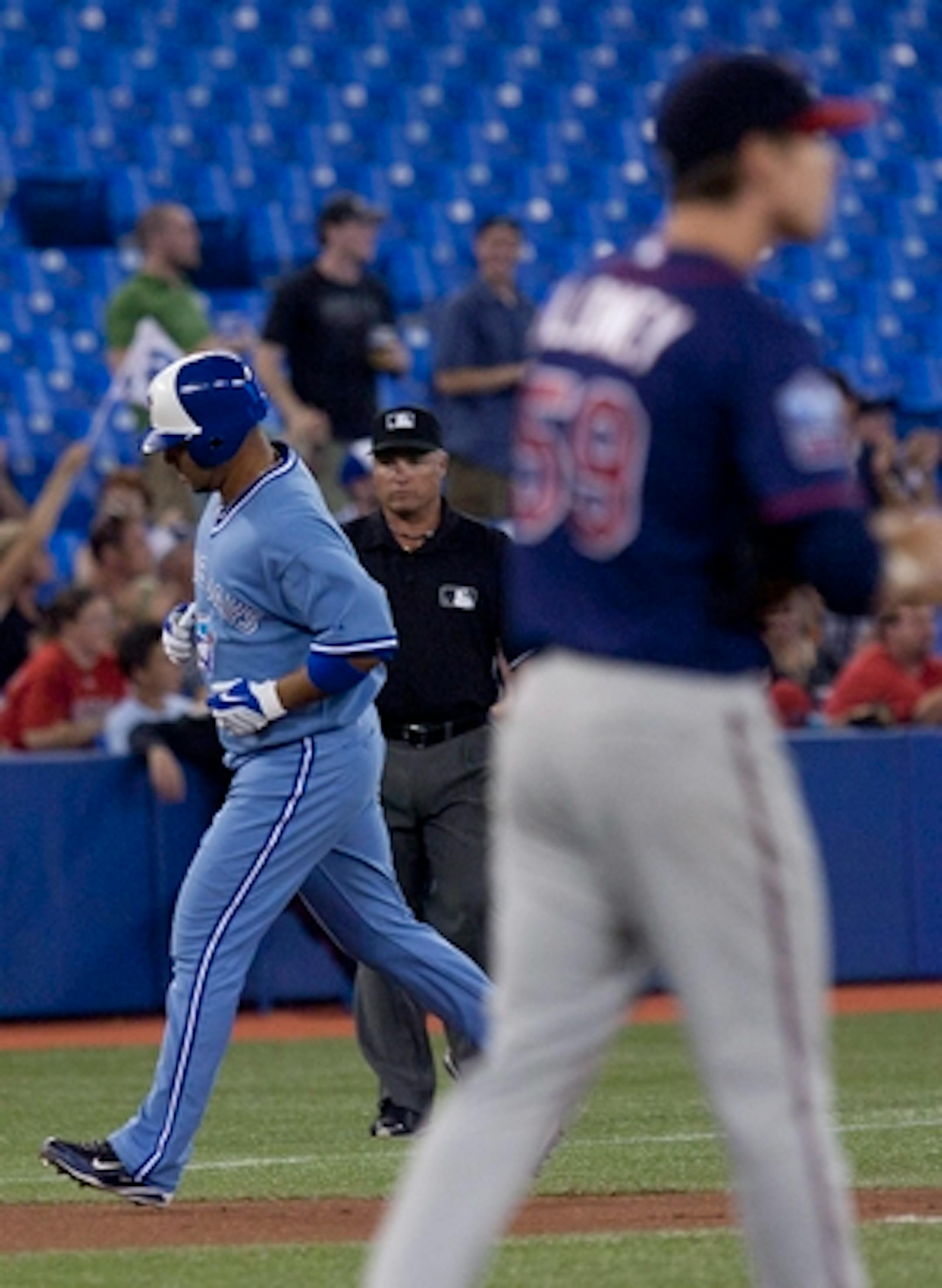 Toronto Blue Jays' Alex Gonzalez,left, rounds third base after hitting a home run off Minnesota Twins pitcher Kevin Slowey,right, during  the first inning of a baseball in Toronto Wednesday, July 7, 2010. (AP Photo/The Canadian Press,Chris Young)