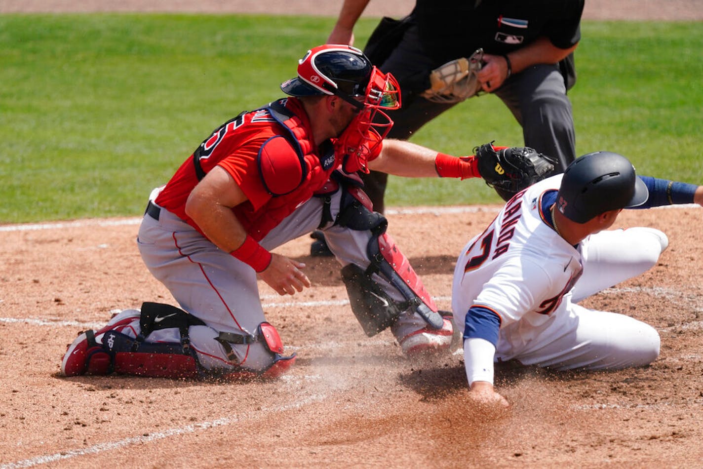 Minnesota Twins' Jose Miranda, right, is tagged out at home by Boston Red Sox catcher Kevin Plawecki, left, as he tries to score in the fifth inning of a spring training baseball game Sunday, March 14, 2021, in Fort Myers, Fla.. (AP Photo/John Bazemore)