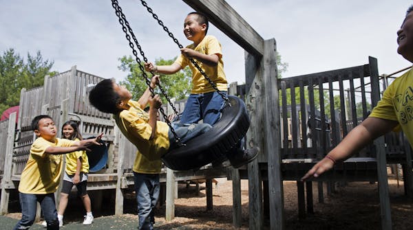 Park Brook 3rd graders Drake Thammavongsa, left, and Aaron Vu are pushed on the tire swing by Elvin Yang, far left, and other elementary students duri