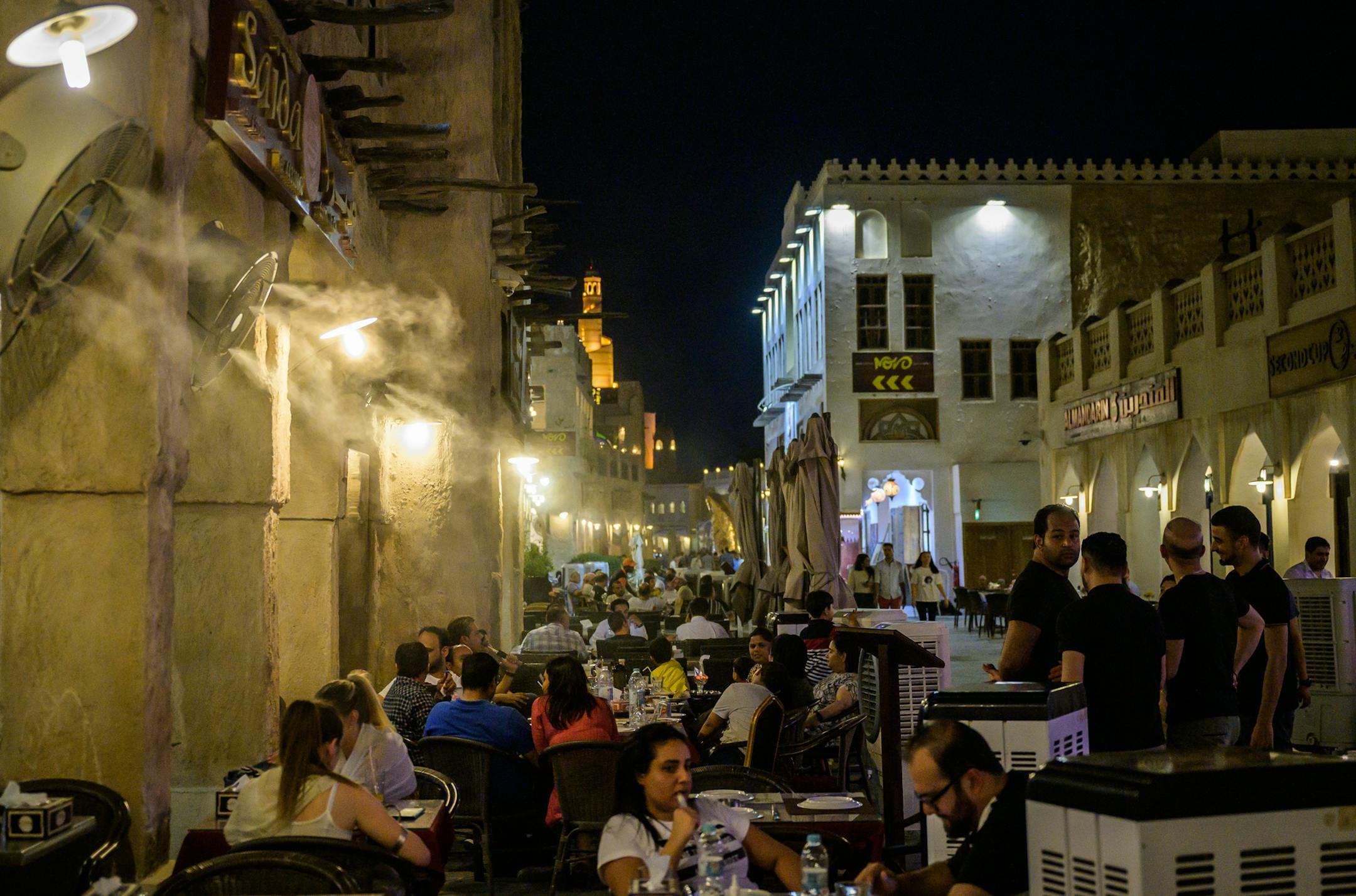Fans equipped with water misters blow moist air on diners who site beside cooling units in Qatar on July 8, 2019. MUST CREDIT: Washington Post photo by Salwan Georges ORG XMIT: 142.0.1951072252