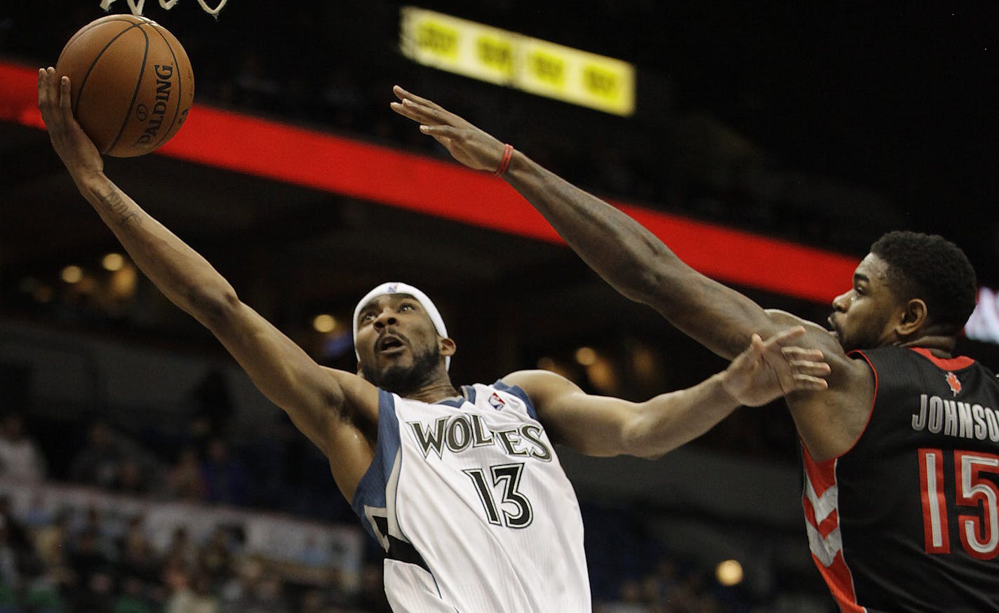 Minnesota Timberwolves forward Corey Brewer (13) goes up to the basket against Toronto Raptors forward Amir Johnson (15) in the second half of an NBA basketball game, Sunday, March 9, 2014, in Minneapolis. The Raptors won 111-104. (AP Photo/Stacy Bengs)