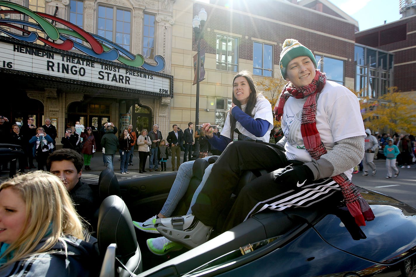 Anna Cruz, left, and Lindsay Whalen, right, greeted fans during their Championship parade along Hennepin Avenue, Friday, October 16, 2015 in Minneapolis, MN.