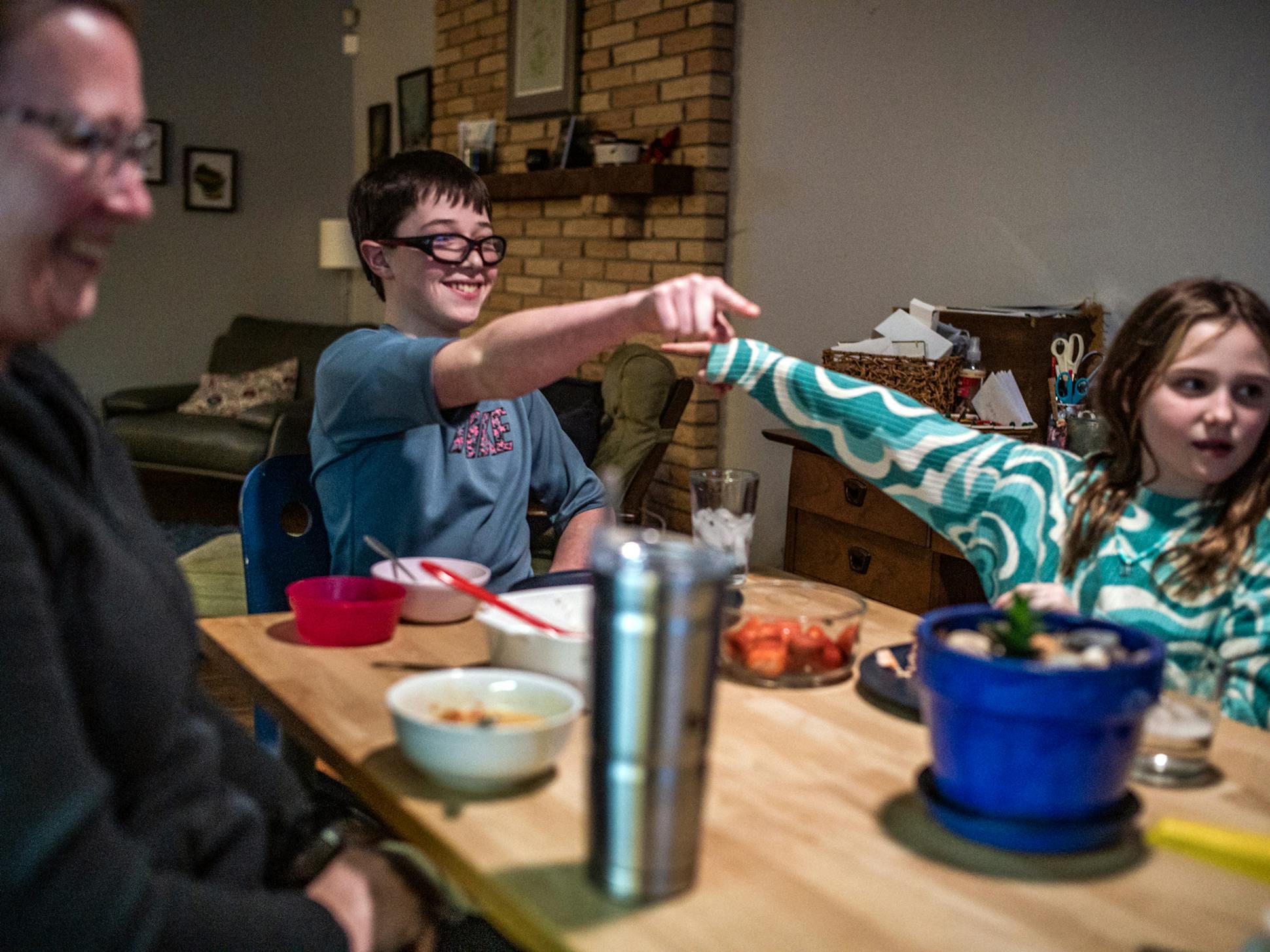 Harrison had dinner with his family, including mother Tara Dobbelaere, left, and sister Odessa, 11. He does well at school in an environment tailored for students with sensory needs.