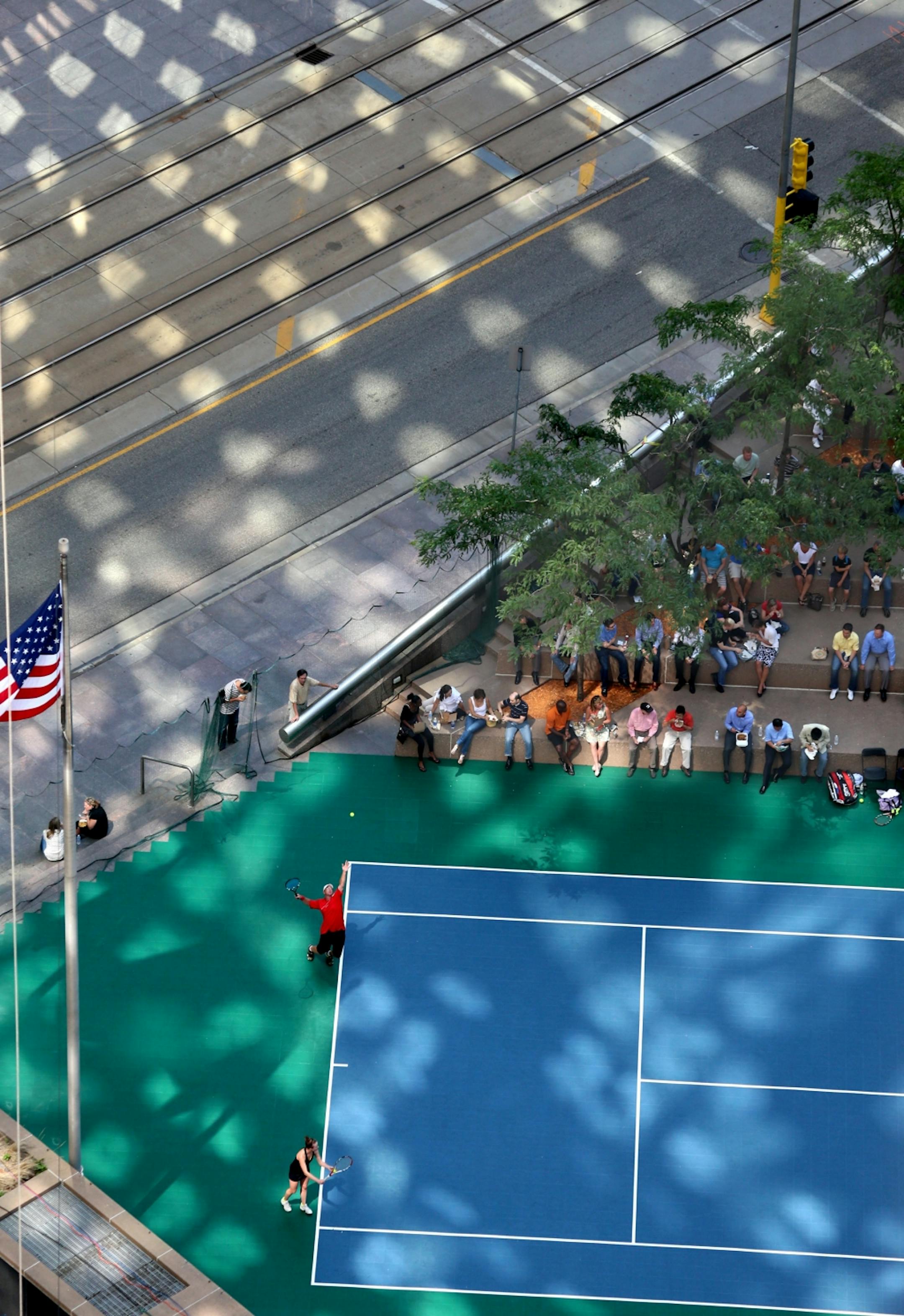 Sunlight reflected of the a high rise in Minneapolis lit up the area of the Mixed Doubles Canadian Pacific Aquatennial Tennis Classic tennis match. This was one of the main events in the kick-off of the 2013 Canadian Pacific Aquatennial Tennis Classic.