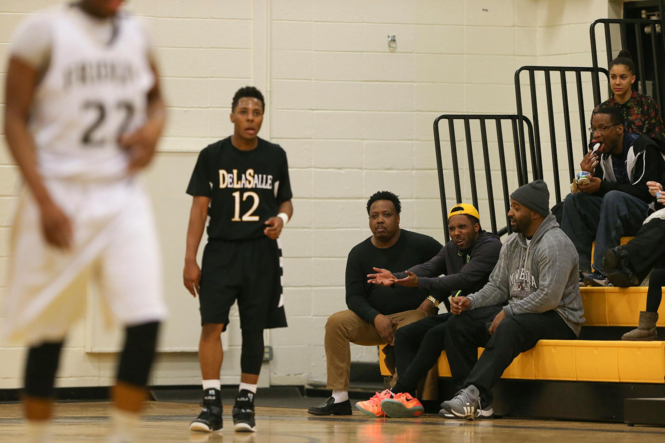 DeLaSalle's Jarvis Johnson stood near his dad, Curtis, in the first row without the hat, and his brother, Ty, gesturing, before taking an inbounds pass in the first half at DeLaSalle. ] JEFF WHEELER ï jeff.wheeler@startribune.com DeLaSalle High School trounced Fridley 69-31 in a boy's basketball game Thursday night, February 12, 2015 at DeLaSalle. The Islanders' Jarvis Johnson is the top preps hoops player in the state and the Gophers' No. 1 recruit for 2015.