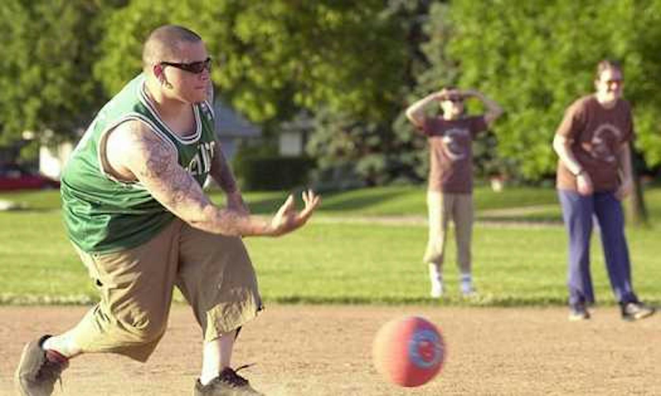 Rocky Lasure of the Kickballin' on a Budget team rolls a pitch to the plate during an adult kickball league game in Bloomington.