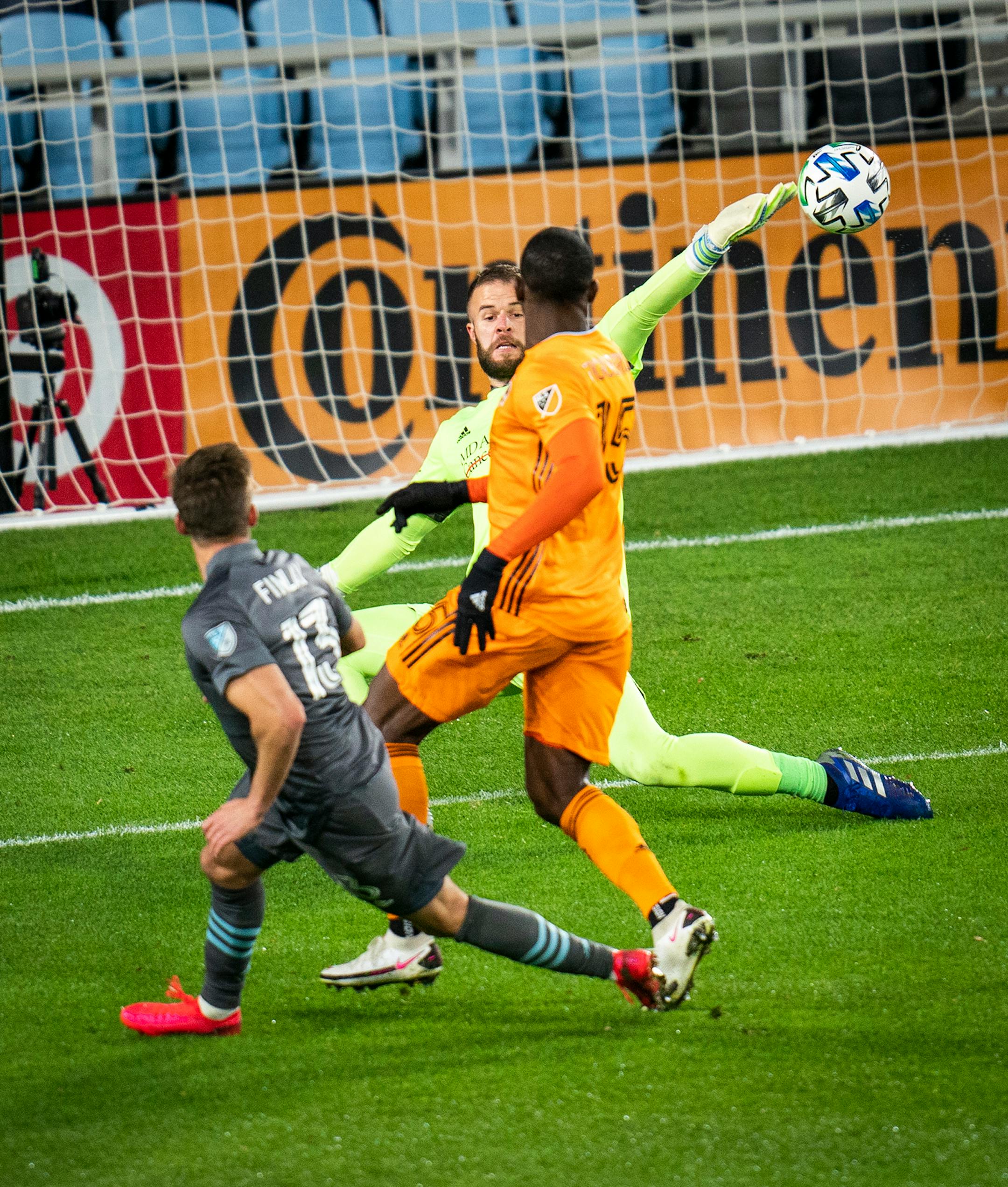 Minnesota United midfielder Ethan Finlay (13) scored a goal on Houston Dynamo goalkeeper Marko Maric (1) as as Houston Dynamo defender Maynor Figueroa (15) pursued during the first half.