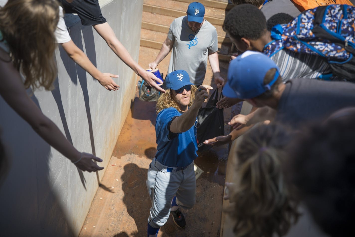 St. Paul Saints pitcher Mark Hamburger handed out gum to kids after Education Day at a St. Paul Saints exhibition game in St. Paul, Minn., on Tuesday, May 16, 2017.