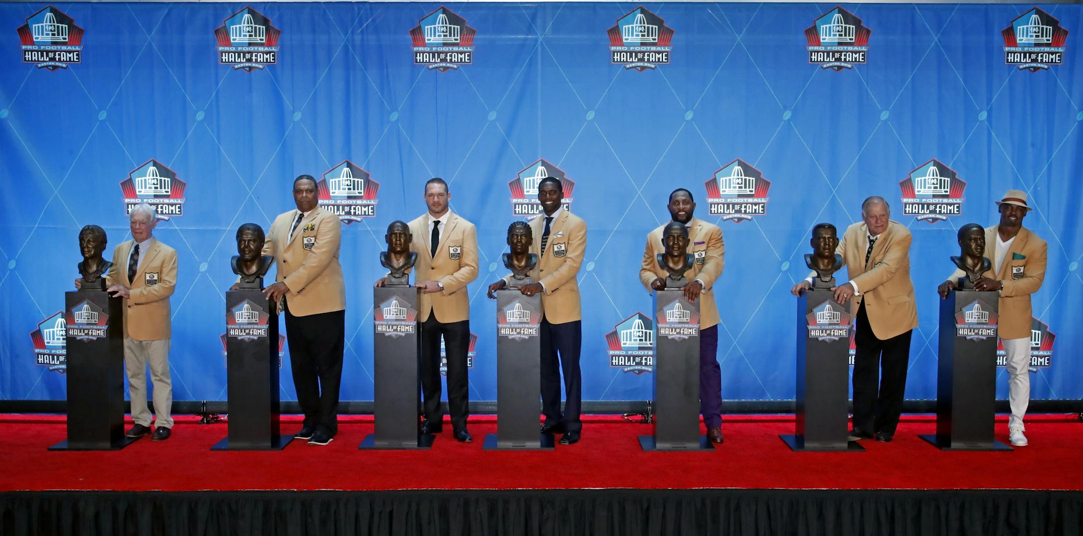 The Pro Football Hall of Fame class of 2018, minus Terrell Owens, poses with their busts following inductions Saturday, Aug. 4, 2018, in Canton, Ohio. From left are Bobby Beathard, Robert Brazile, Brian Urlacher, Randy Moss, Ray Lewis, Jerry Kramer and Brian Dawkins.
