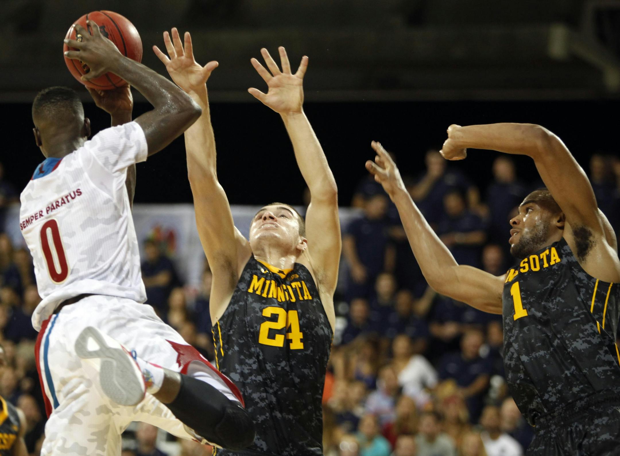Minnesotaís Andre Hollins, right, and Joey King, center, try to block Louisvilleís Terry Rozier during a NCAA college basketball Armed Forces Classic game inside a hangar at the United States Coast Guard Air Station base in Aguadilla, Puerto Rico, Friday, Nov. 14, 2014. (AP Photo/Ricardo Arduengo) ORG XMIT: XRA123