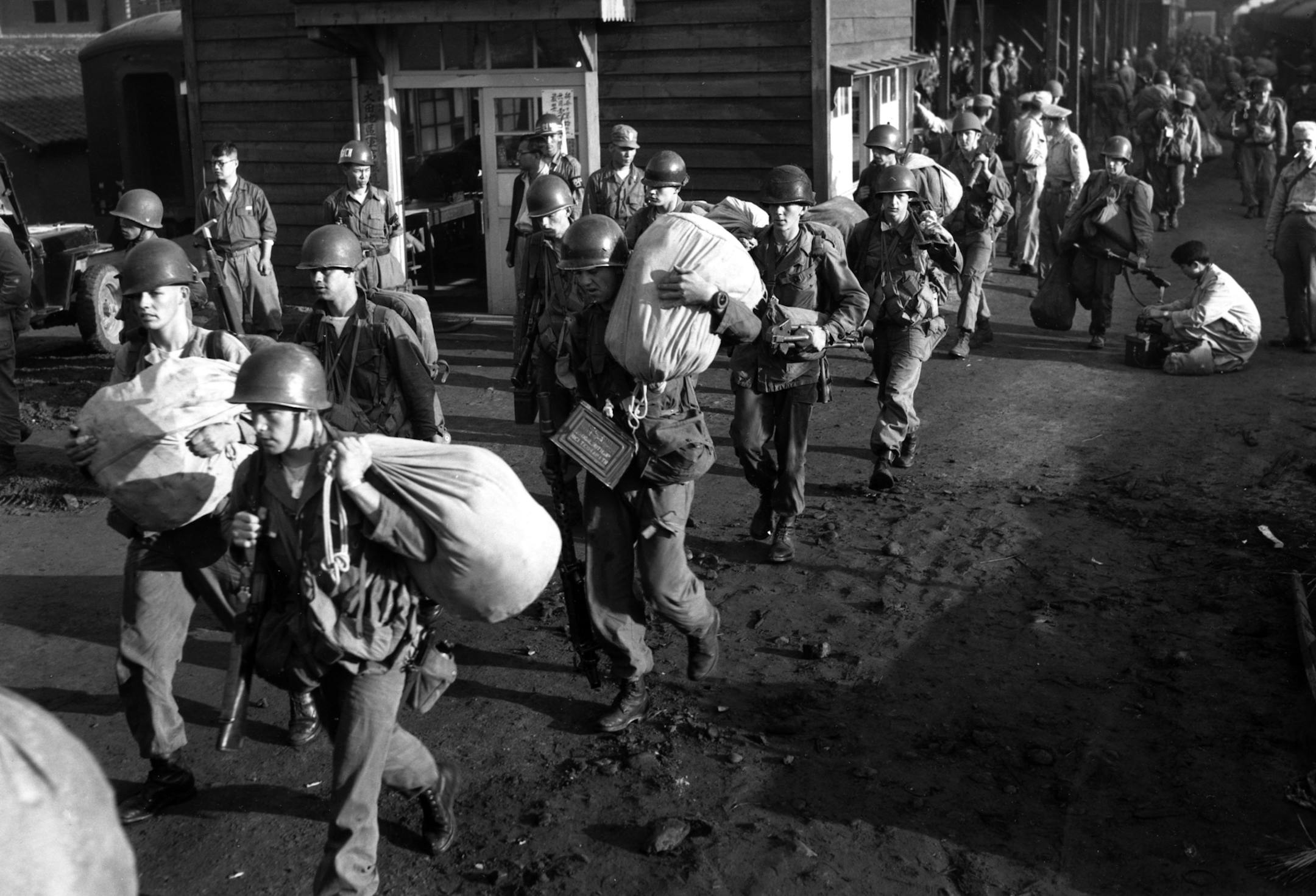 FILE - In this July 5, 1950, file photo, American foot soldiers leave the railroad station at Taejon, South Korea, en route to the battle front against North Korea. The most tangible outcome of the summit between President Donald Trump and North Korean leader Kim Jong Un seems to be a commitment to recover the remains of U.S. military personnel missing in action and presumed dead from the Korean War. In a joint statement signed by the leaders Tuesday, the countries committed to the recovery of t