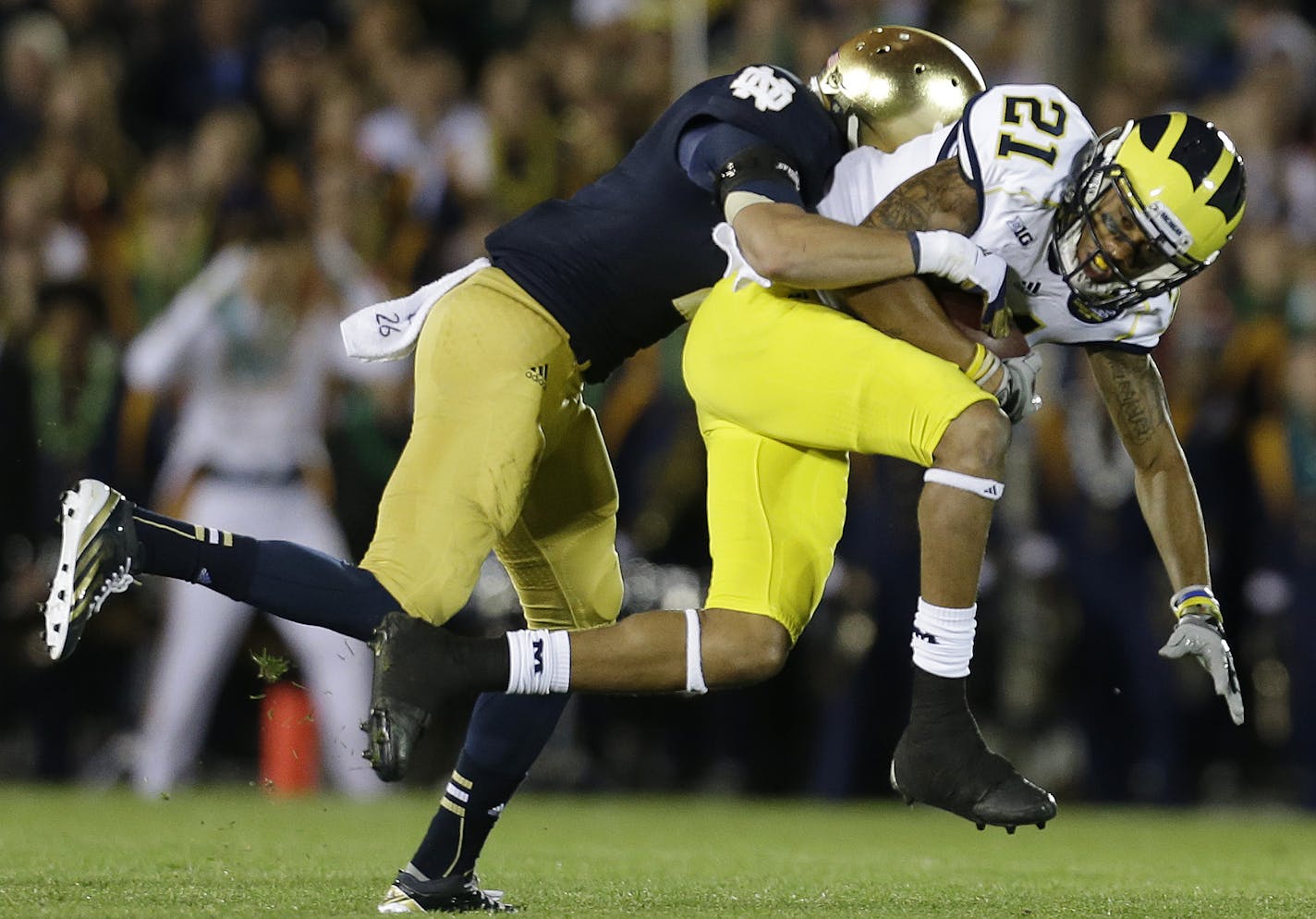 Michigan's Roy Roundtree (21) is tackled by Notre Dame's Bennett Jackson during the first half of an NCAA college football game Saturday, Sept. 22, 2012, in South Bend, Ind. (AP Photo/Darron Cummings) ORG XMIT: INDC109