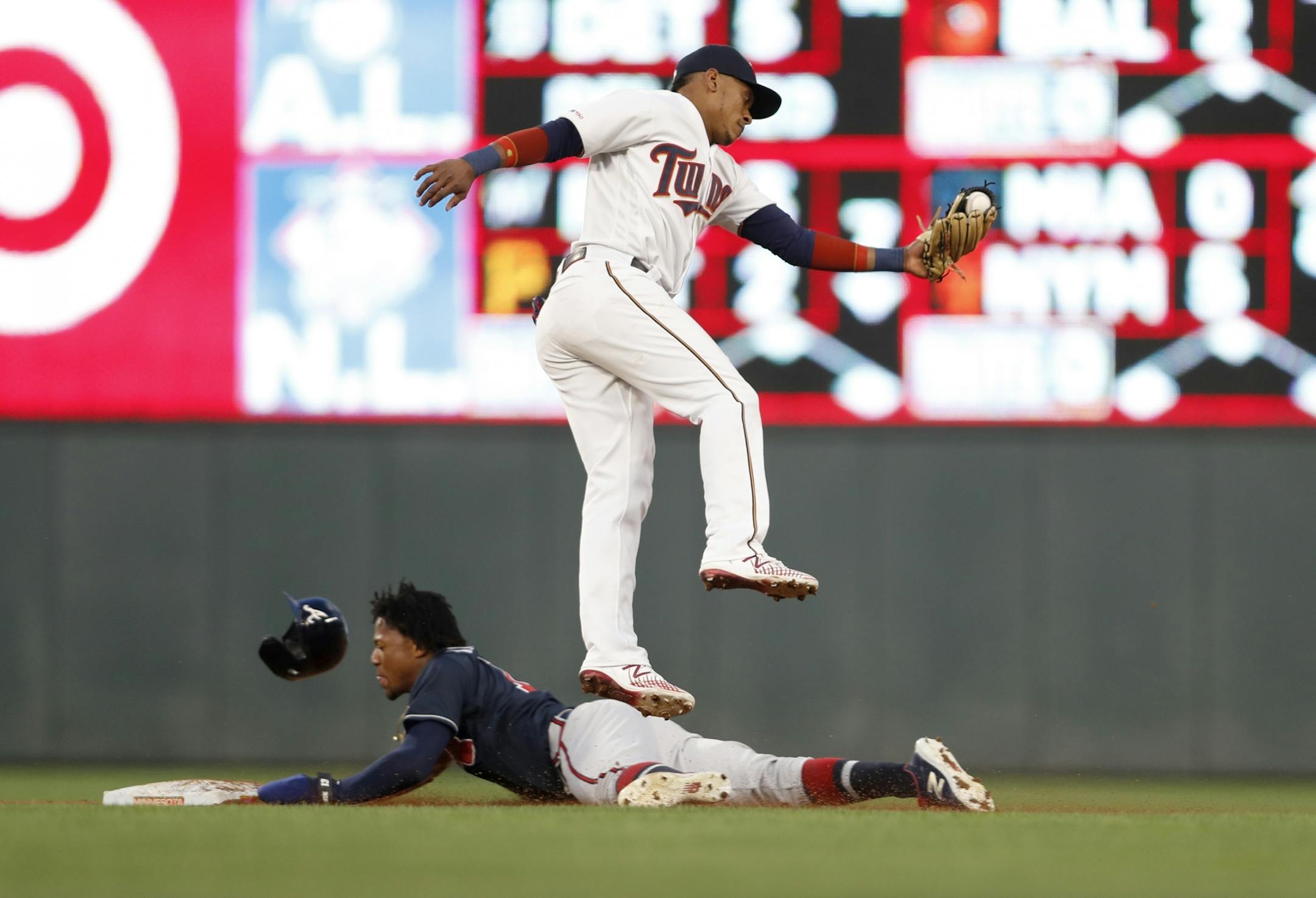 Minnesota Twins shortstop Jorge Polanco (11) catches the ball a bit late and Atlanta Braves right fielder Ronald Acuna Jr. (13) is safe at second after stealing the base in the fifth inning.