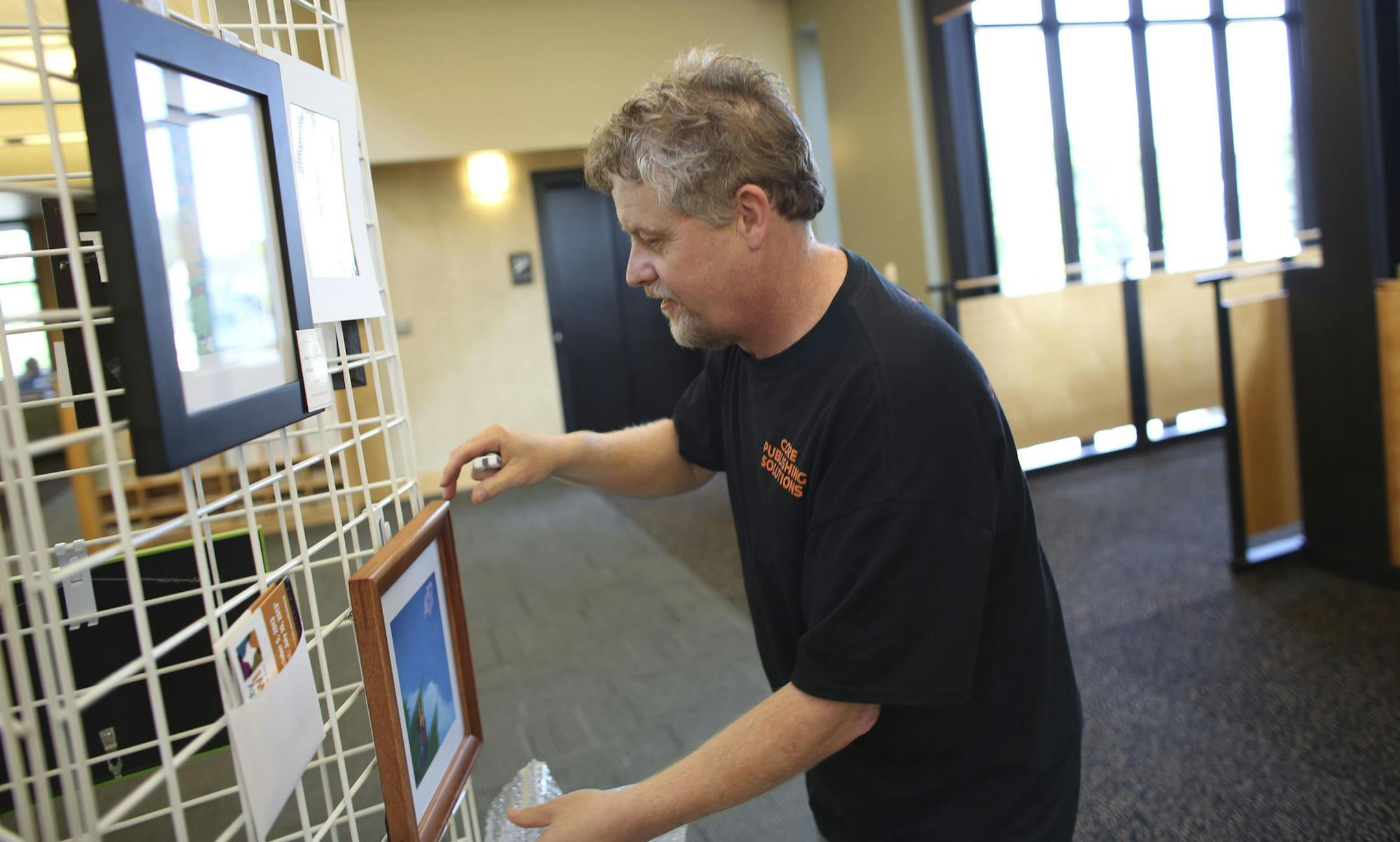 Artist Franklin Haws hung up more of his art for display at the Shakopee Public Library in Shakopee Min., Wednesday, September , 2013. Haws along with other artists will be exhibiting in the Scott County Art Crawl. Some of the artists are being displayed at three different libraries before the Crawl. ] (KYNDELL HARKNESS/STAR TRIBUNE) kyndell.harkness@startribune.com