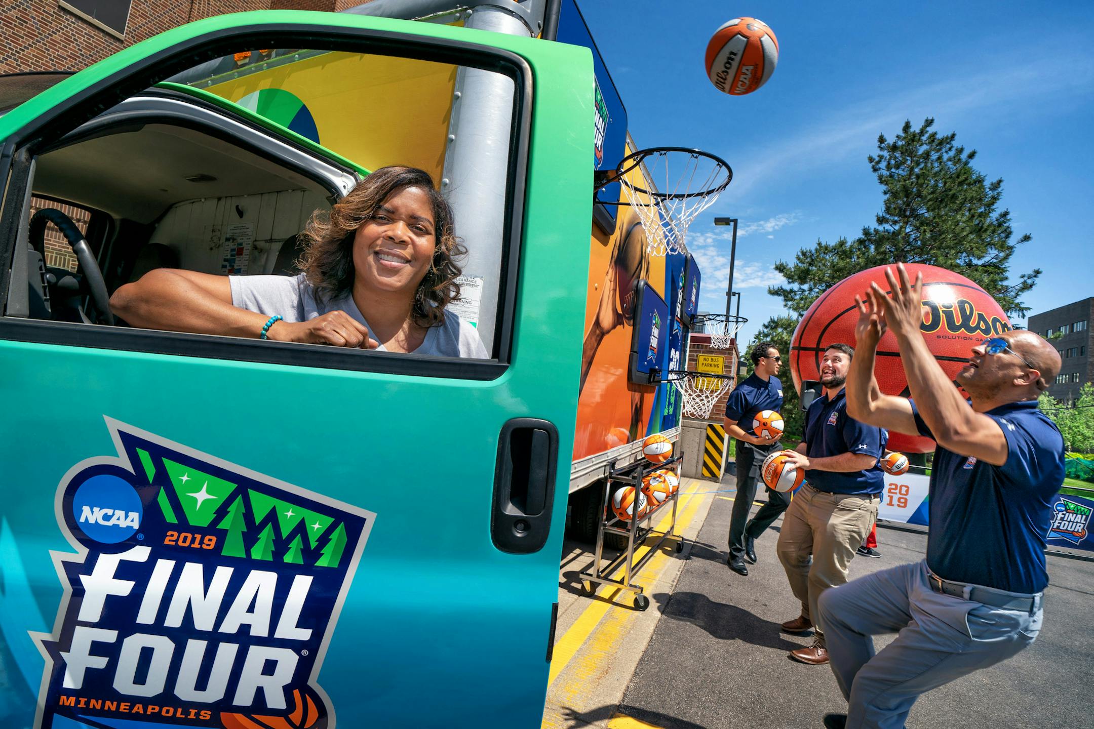Cydni Bickerstaff, VP of event operations with the Fan Jam truck. Staff members shot baskets on the side of the truck. from left, Cordell Smith, Jack Bernstein and Ivan Cardona.