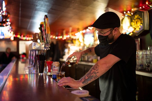 Bartender Justin Fowler poured a shot at Dusty’s in Minneapolis on Jan. 6, a few minutes after the mask mandate went into effect.