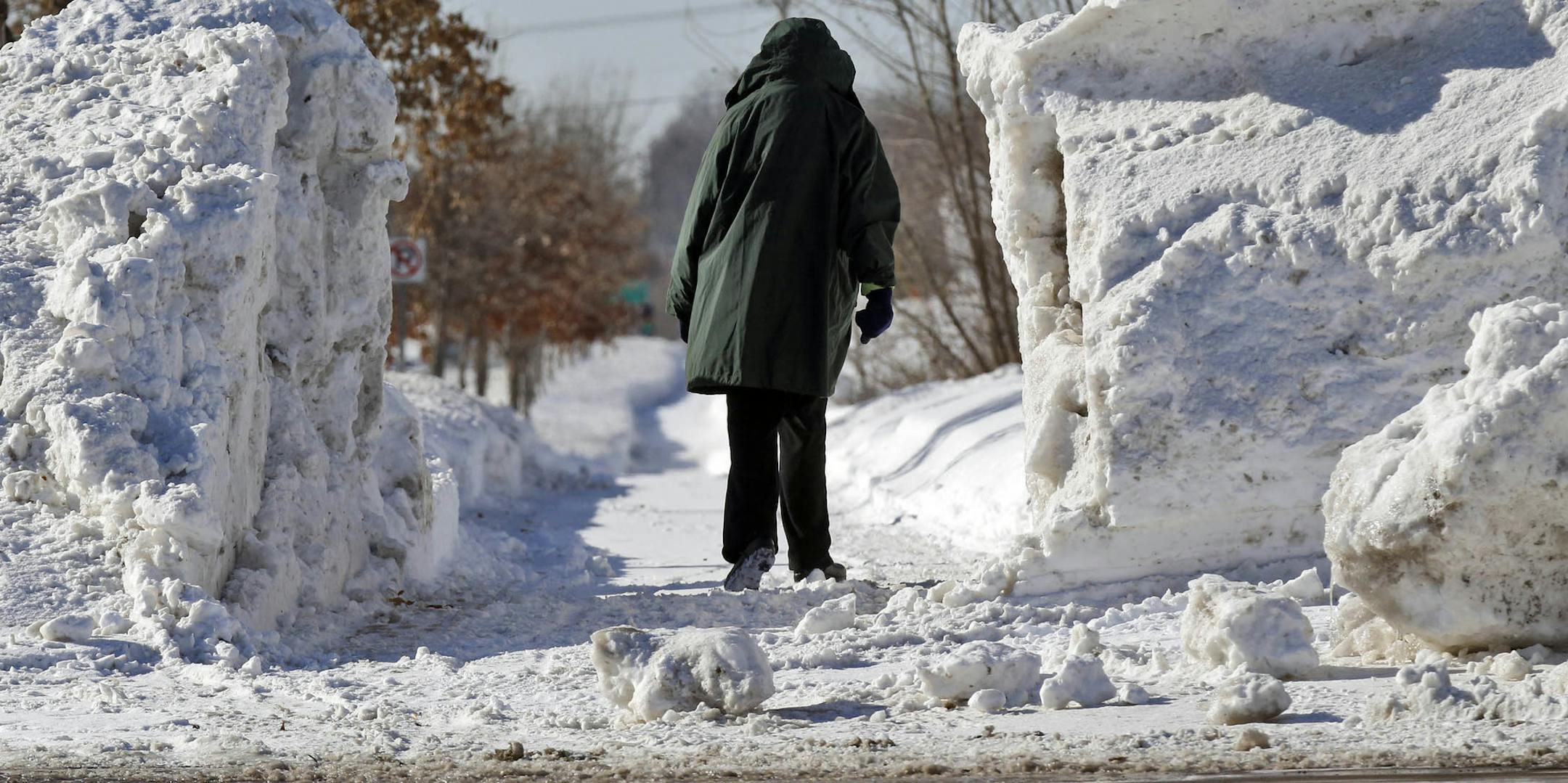Heavy area winter snowfall has piled up to inhibit parking spaces and open walkways. A pedestrian walkway in White Bear Township was kept open by chiseling through a large wall of plowed snow. (MARLIN LEVISON/STARTRIBUNE(mlevison@startribune.com)
