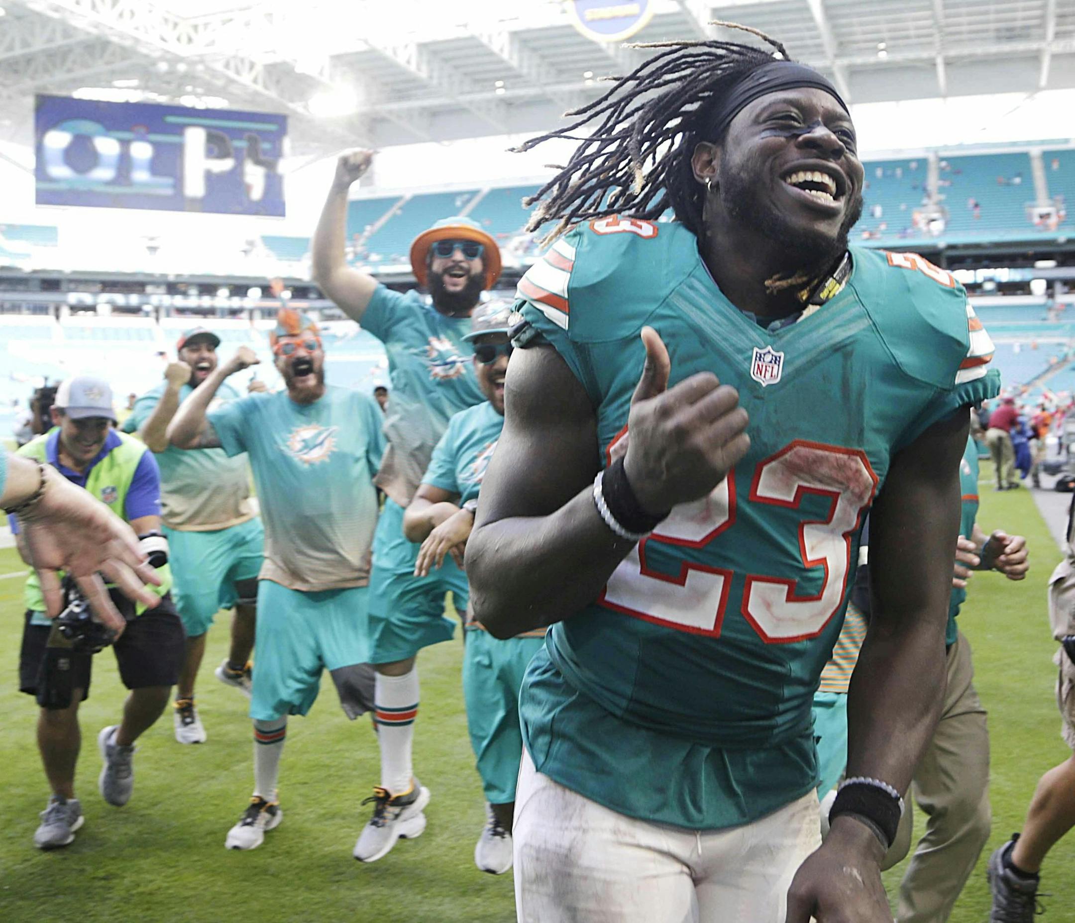 Miami Dolphins running back Jay Ajayi (23) is congratulated as he leaves the field, at the end of an NFL football game against the Buffalo Bills, Sunday, Oct. 23, 2016, in Miami Gardens, Fla. Ajayi tied an NFL record by surpassing 200 yards rushing for the second game in a row, helping the Miami Dolphins rally past the Buffalo Bills 28-25. (AP Photo/Lynne Sladky)