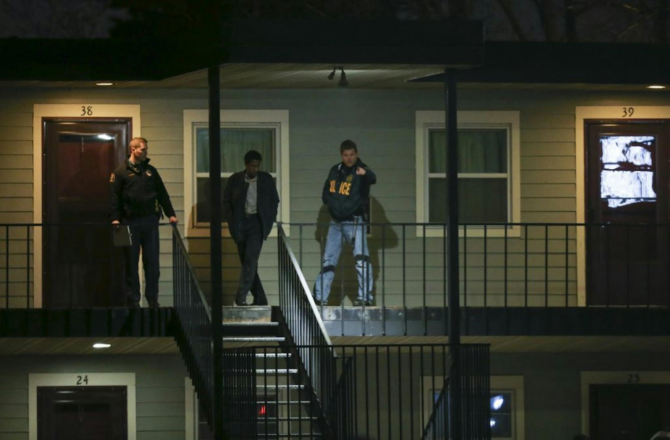 Police investigators with a man who was in one of the rooms at the Midway Motel late Tuesday night.