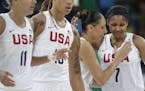 United States' Diana Taurasi, second from right, pats teammate Maya Moore as they walk off the court during a women's quarterfinal round basketball ga