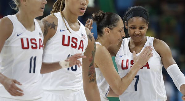 United States' Diana Taurasi, second from right, pats teammate Maya Moore as they walk off the court during a women's quarterfinal round basketball ga
