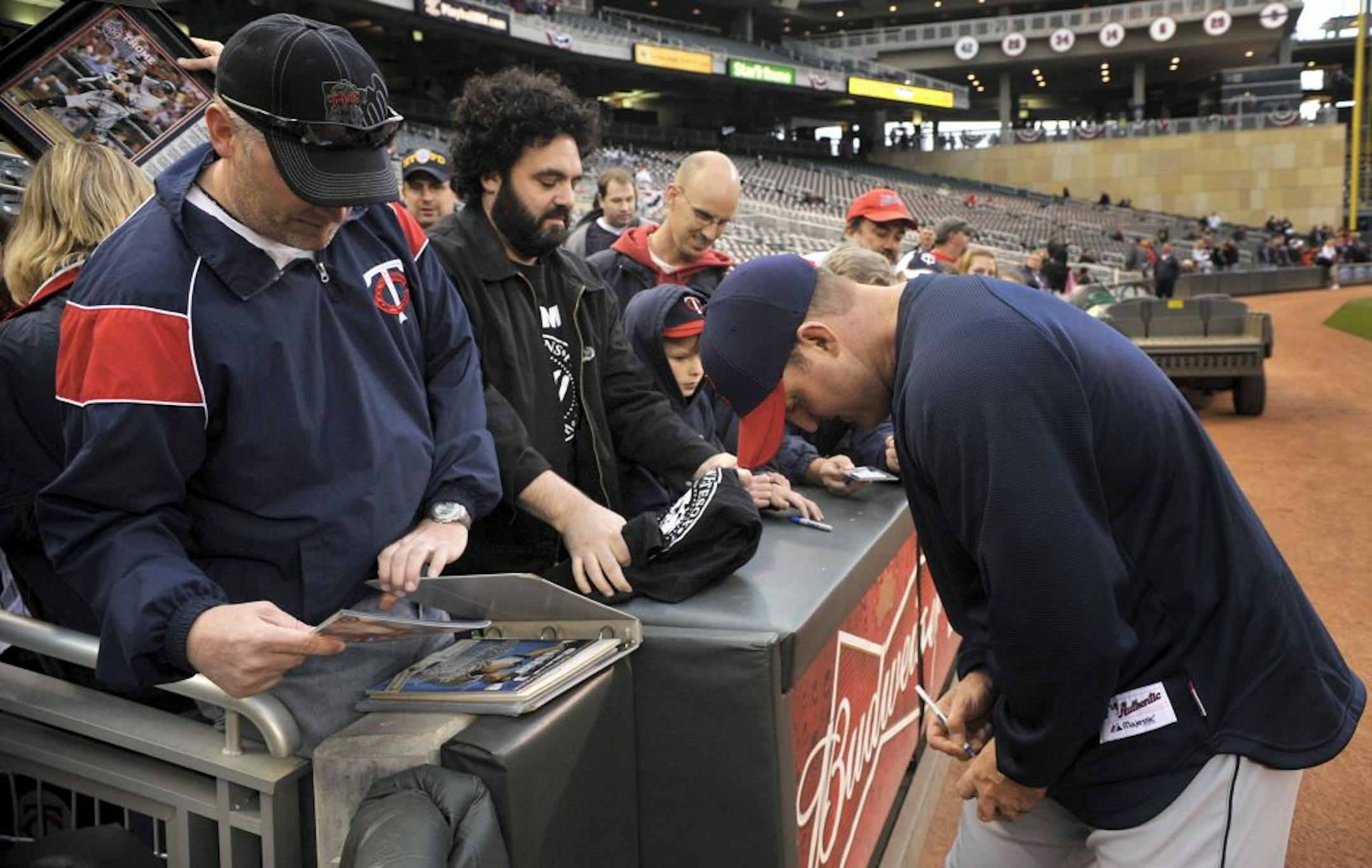 Cleveland Indians' Jim Thome, right, signs an autograph for a Minnesota Twins' fan prior to their baseball game, Friday, Sept. 16, 2011, in Minneapolis. This is the first game back at Target Field for Thome after being traded to the Indians last month.