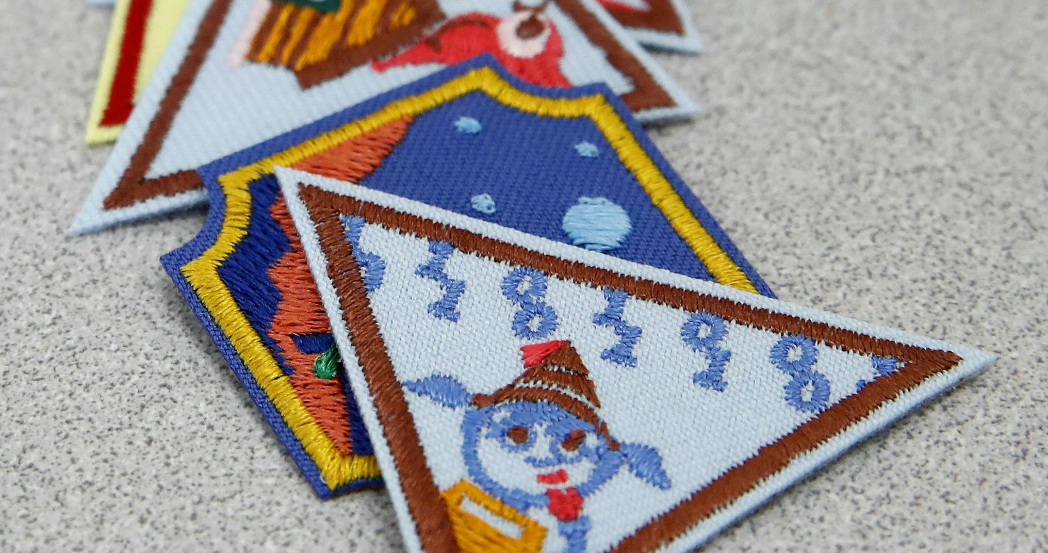 In this July 21, 2017 photo, a Girl Scout badge for learning how to program a robot is seen atop a sample of new badges focused on science, technology, engineering and math in Owings Mills, Md. The new group of 23 badges takes a progressive approach to STEM and also nudges girls to become citizen scientists using the great outdoors as their laboratory. (AP Photo/Patrick Semansky)