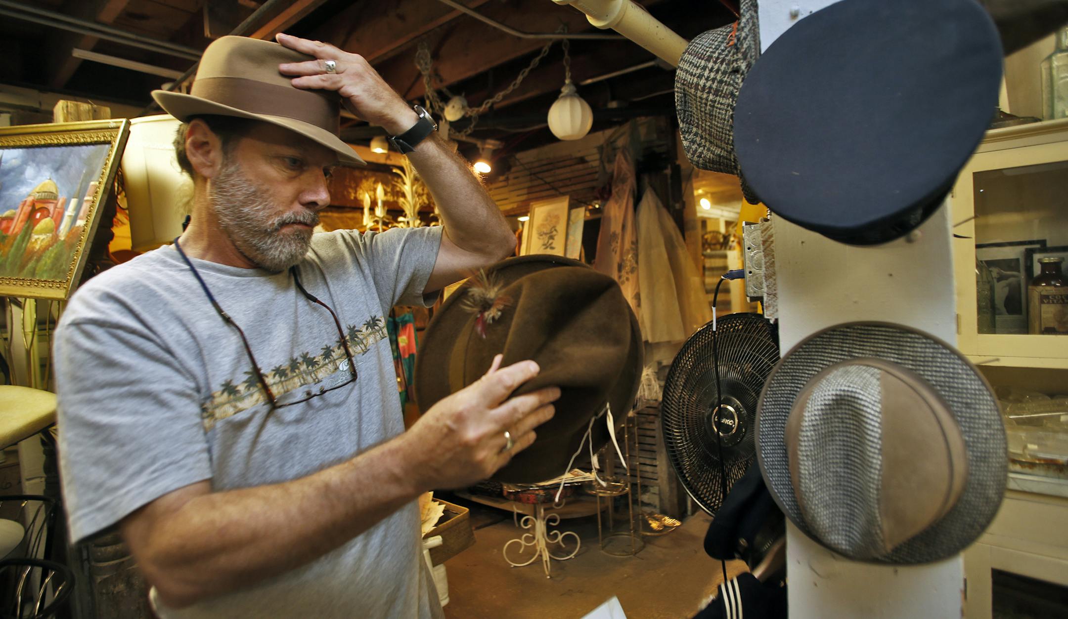 Men are spending an increasing amount of time in antique shops, referred to as mantiquing. Hunt and Gather shop in south Minneapolis attracts men looking for vintage items. Norbert Schiller of Minneapolis found a hat to his liking as he helped his college-bound son to find items for his dorm room. (MARLIN LEVISON/STARTRIBUNE(mlevison@startribune.com)