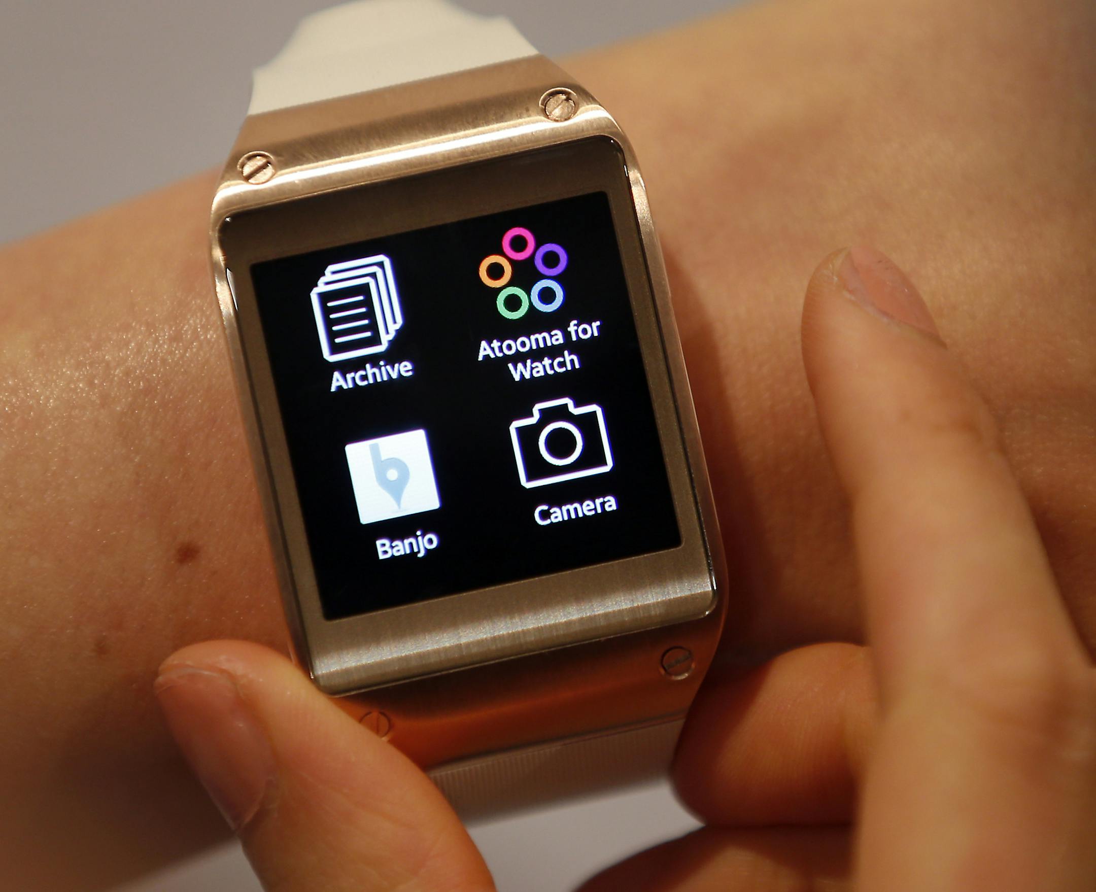 A model touches wears a Samsung Galaxy Gear smartwatch in Berlin, Germany, Wednesday, Sept. 4, 2013. Samsung has unveiled a highly anticipated digital wristwatch well ahead of a similar product expected from rival Apple. The so-called smartwatch is what some technology analysts believe could become this year's must-have holiday gift. Samsung unveiled the Galaxy Gear on Wednesday in Berlin ahead of the annual IFA consumer electronics show. (AP Photo/Michael Sohn)