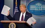 President Donald Trump held up copies of news articles about mail-in ballots during a coronavirus briefing at the White house in July 2020. 