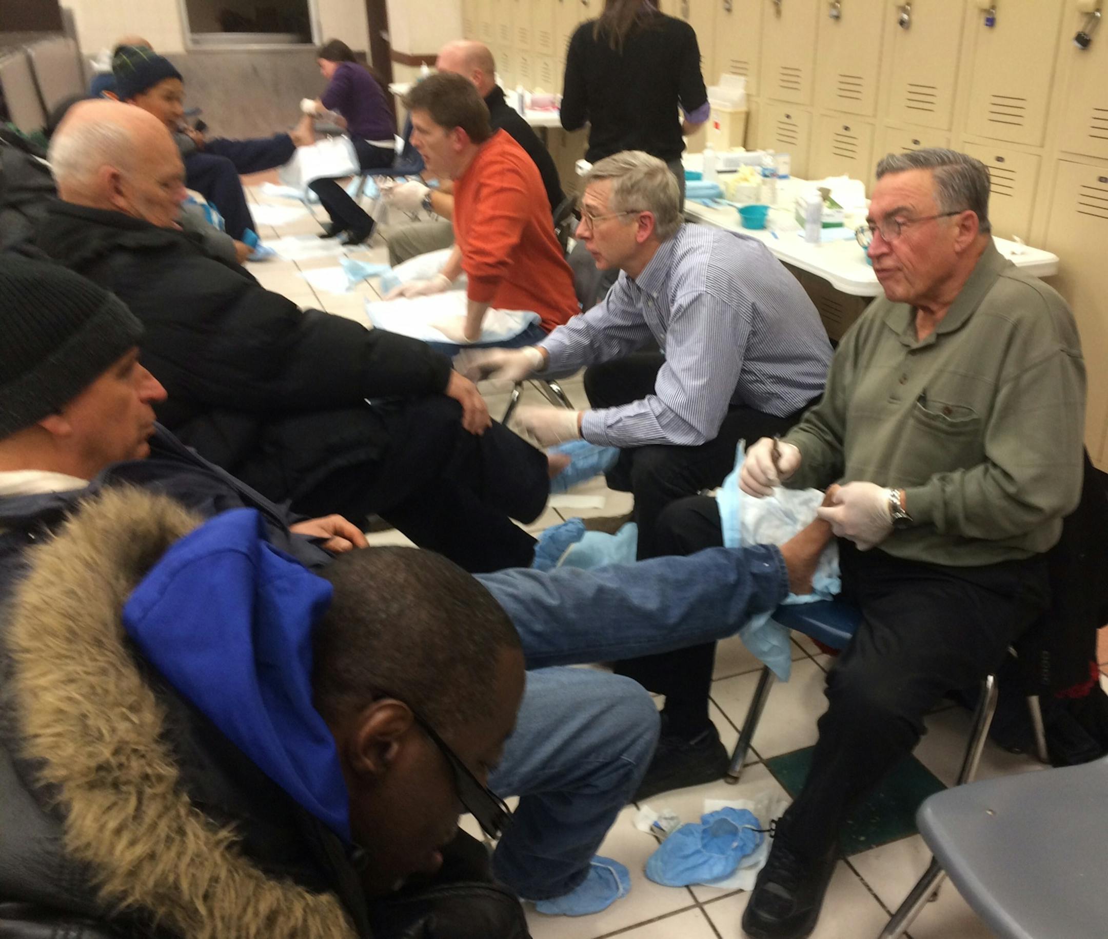 Dr. George Nemanich (right), 75, a semi-retired surgeon and regular volunteer, examined the feet of homeless and working-poor with other volunteer medical professionals at St. Paul's Dorothy Day Center in late November
