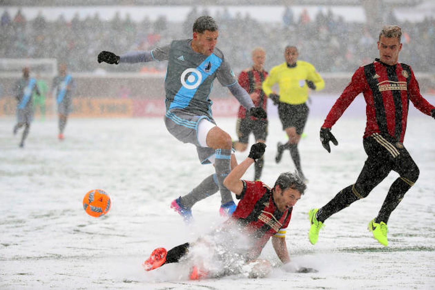 Minnesota United forward Christian Ramirez, center top, and Atlanta United defender Michael Parkhurst battle for the ball in the snow during the first half of an MLS soccer game Sunday, March 12, 2017, in Minneapolis, Minn. (Elizabeth Flores/Star Tribune via AP)