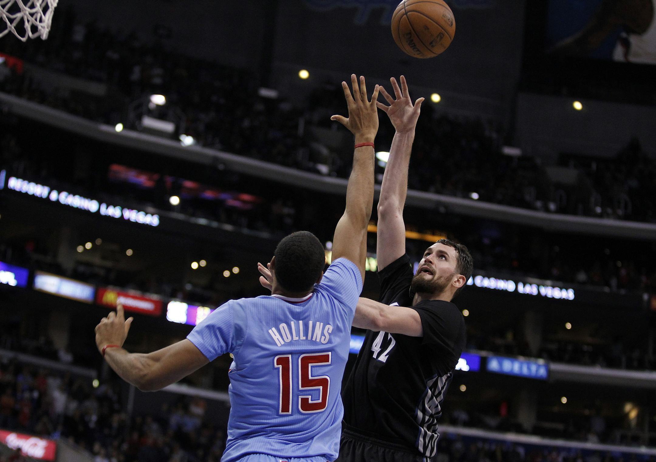 Minnesota Timberwolves forward Kevin Love, right, shoots over Los Angeles Clippers center Ryan Hollins (15) in the overtime period of an NBA basketball game in Los Angeles on Sunday, Dec. 22, 2013. Clippers won the game 120-116 in overtime. (AP Photo/Alex Gallardo)