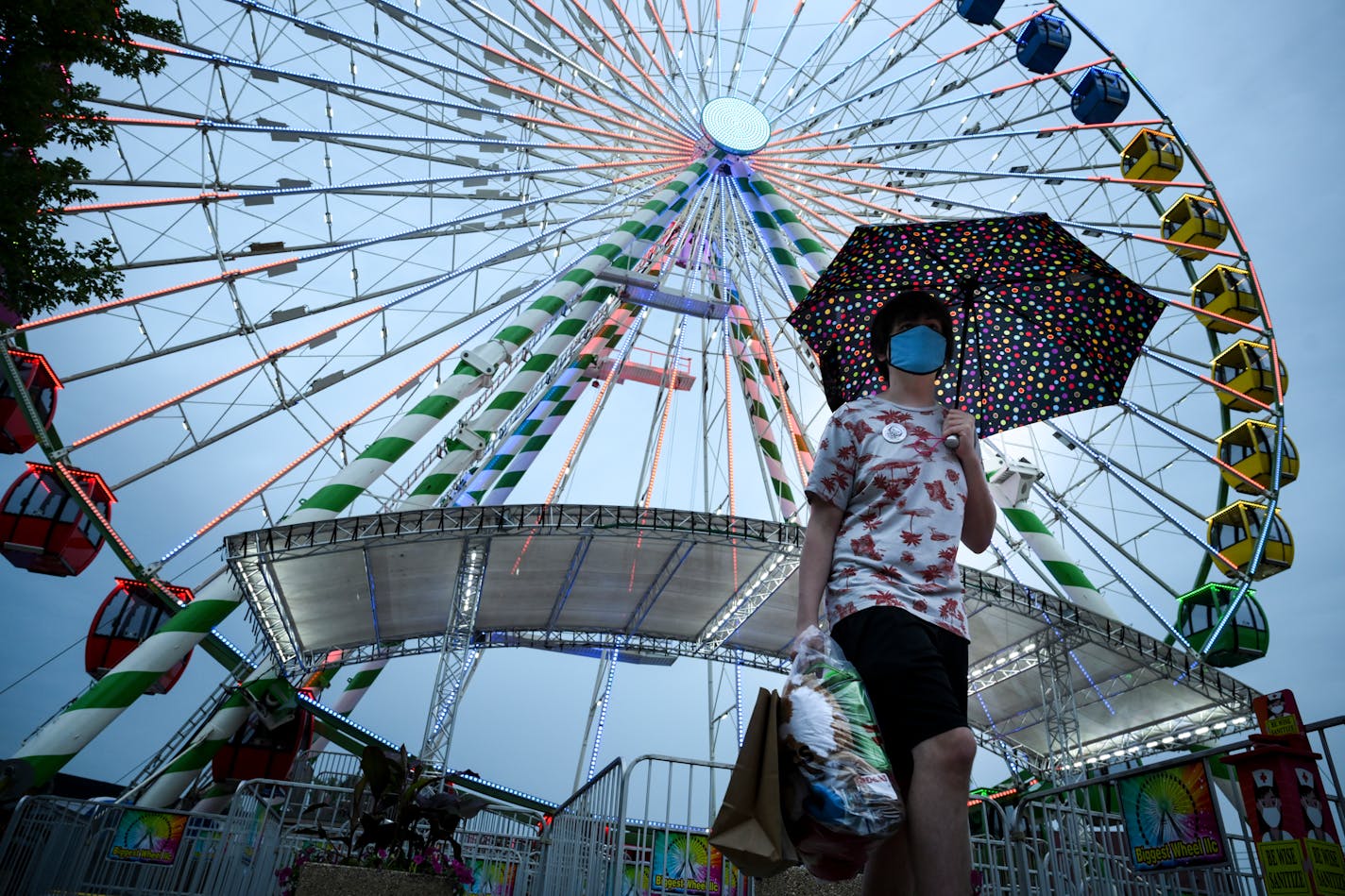 Justin Stafki, 17, of White Bear Lake, walked away from the Great Big Wheel after a ride with his mother, Barb. They say they were headed somewhere dry as raindrops began to fall. ] AARON LAVINSKY • aaron.lavinsky@startribune.com