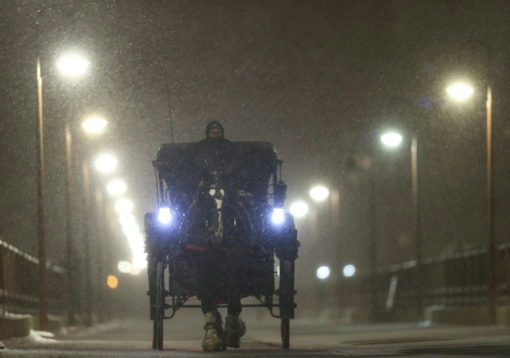 Mike Miller of The Hitching Company carried passengers Noah Perschbacher and Maddie Riegle of Grand Rapids, Michiganin his carriage on an excursion across the Stone Arch Bridge Monday night.