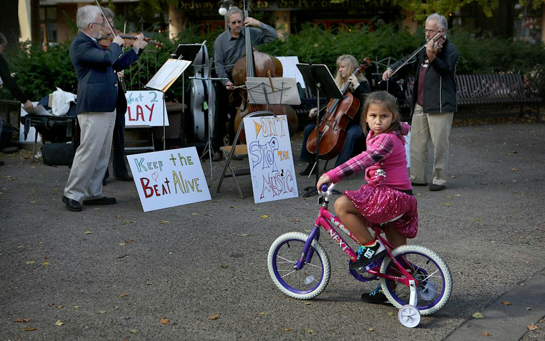 Six-year-old Isabella Suarez, St. Paul, stopped to listen as SPCO musicians Michal Sobieski, Brenda Mickens, Fred Bretschger, Sarah Lewis, and Tamás Strasser played during a union rally in Rice Park Tuesday.