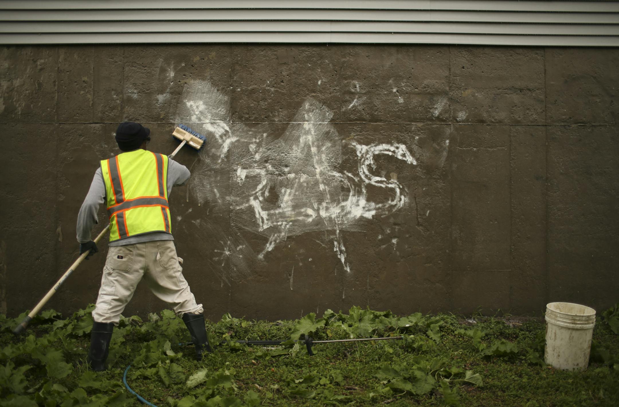 Robert M. applied another coat of solvent to try to remove remaining paint on a retaining wall near Interstate 35E in St. Paul on Thursday.