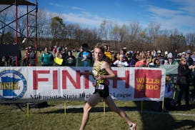 Jakob McCleary from Perham looks behind as he crosses the finish line to win the 2021 Class 1A boys cross-country state meet in Northfield.