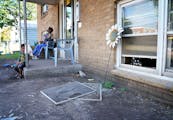 Displaced residents Denise Meanweather and her grandson sat Wednesday outside the front door of their apartment building in north Minneapolis. The fam