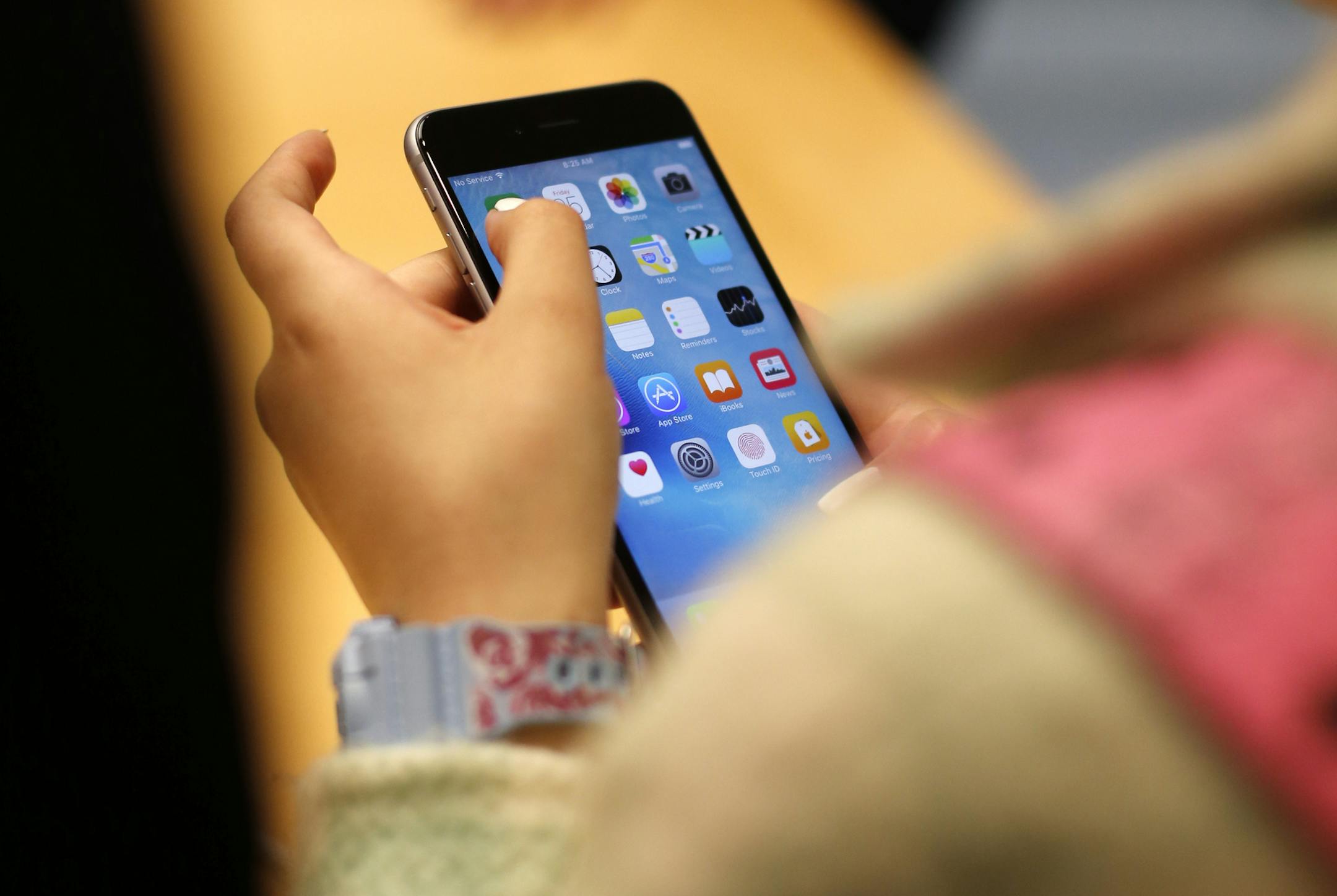 FILE - In this Sept. 25, 2015, file photo, a child holds an Apple iPhone 6S at an Apple store on Chicago's Magnificent Mile in Chicago. The World Health Organization Wednesday, April 24, 2019, issued its first-ever guidance for how much screen time children under 5 should get: not very much, and none at all for those under 1. (AP Photo/Kiichiro Sato, File)