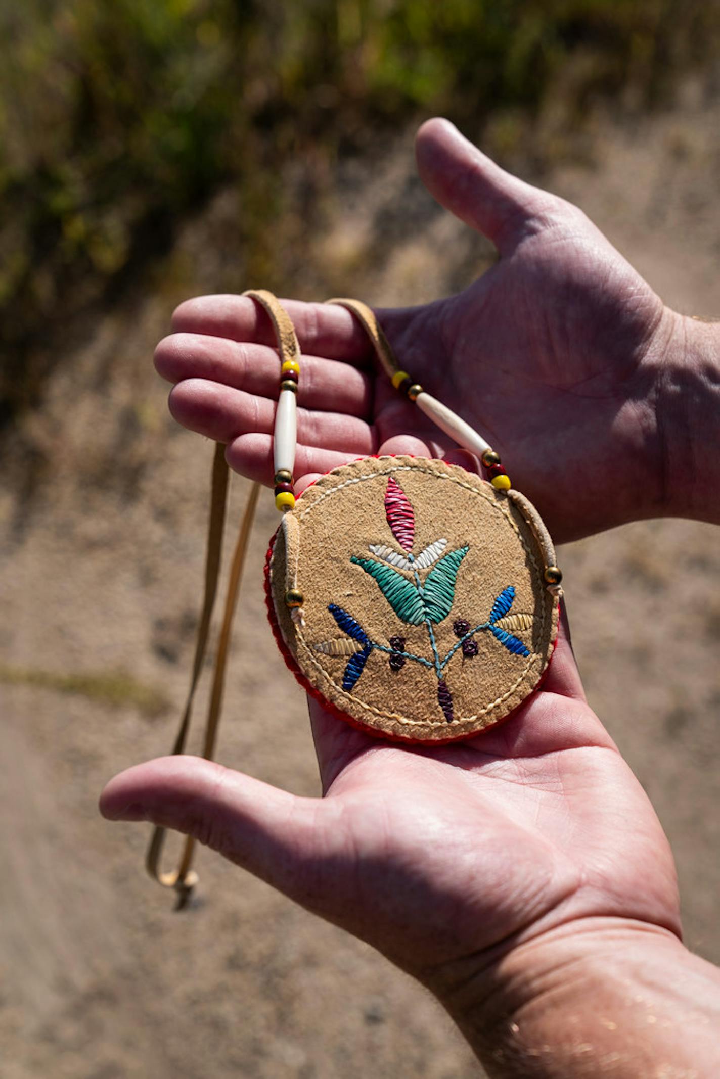 Andy Vig held a Dakota floral beadwork medallion, the type of cultural object to be displayed at the new cultural center.