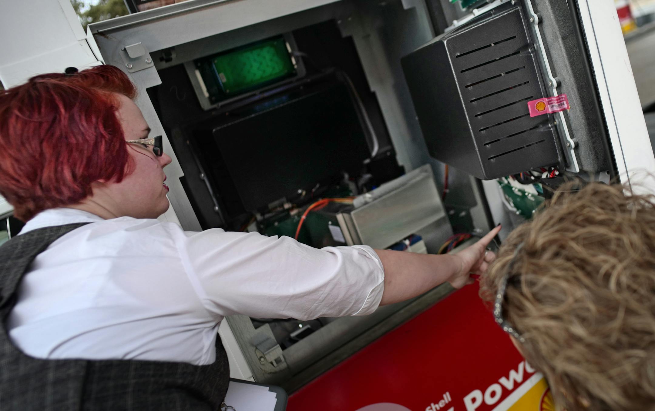 At the Lone Oak Market gas station, one of the first participants in Eagan's SkimStop program, assistant general manager Kristina Ellis, left, showed cashier manager Michelle Moseng how a couple seals, double locks and inspections can help prevent skim fraud . Richard Tsong-Taatarii/rtsong-taatarii@startribune.com