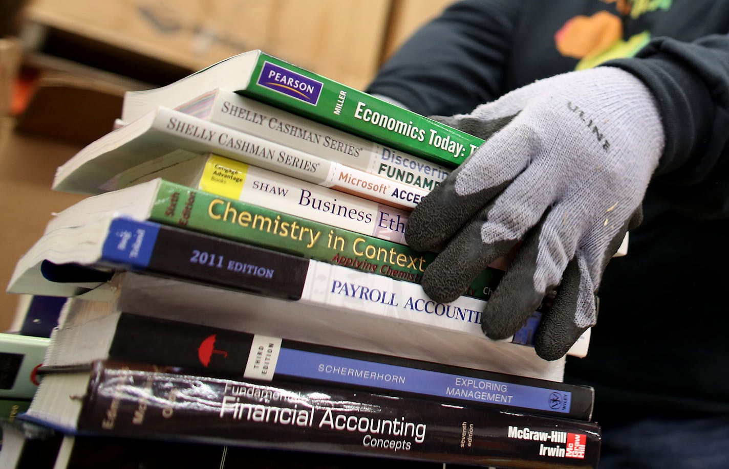 Norma Crumble, an employee for seven year at Book for Africa, sorted through donated books. Some of the books that come in can be damaged to the point that they have to be recycled. ] (KYNDELL HARKNESS/STAR TRIBUNE) kyndell.harkness@startribune.com At Books for Africa in St Paul Min., Tuesday, December 23, 2014. A ceremony recognizing the shipment of more than 22,000 primary and secondary reading books collected by Books For Africa to Liberia featuring Ahmed Sirleaf, the adapting advisor for the