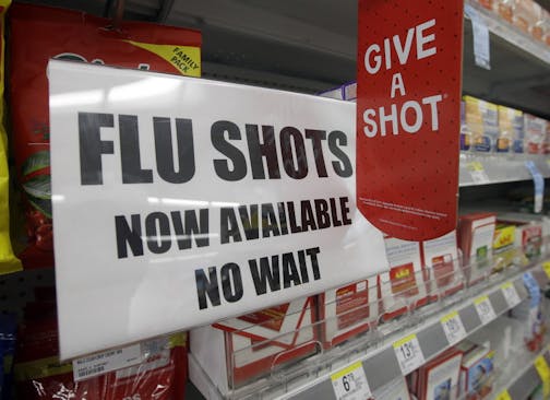 FILE - In this Sept. 16, 2014 file photo, a sign telling customers that they can get a flu shot in a Walgreen store is seen in Indianapolis. Kids may get more of a sting from flu vaccination this fall: Doctors are gearing up to give shots only, because U.S. health officials say the easy-to-use nasal spray version of the vaccine isn't working as well as a jab. Needle-phobic adults still have some less painful options. But FluMist, with its squirt into each nostril, was the only ouch-free alternat