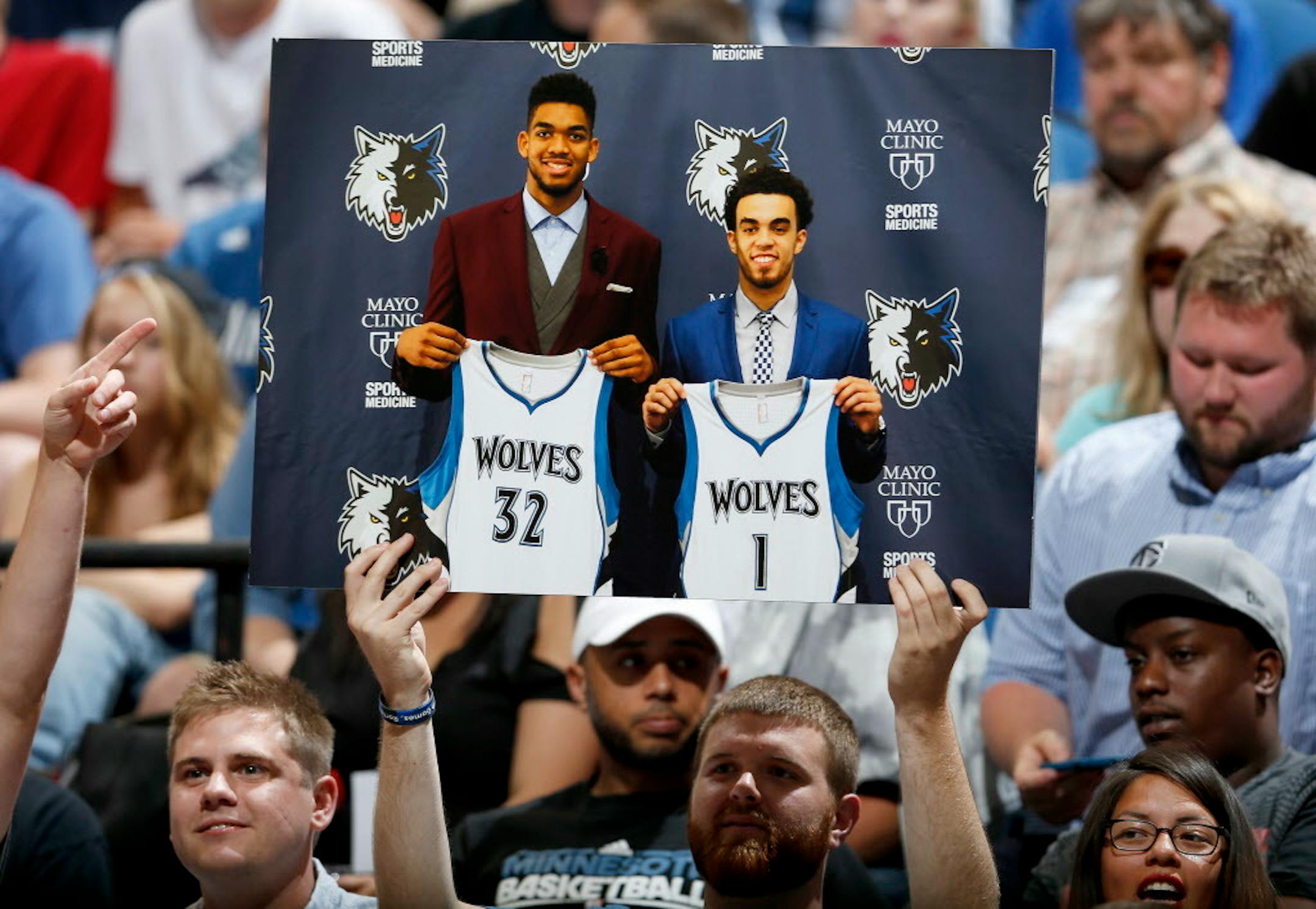 A fan held up a photo of Timberwolves first round draft picks Karl-Anthony Towns and Tyus Jones during a team scrimmage at Target Center. ] CARLOS GONZALEZ cgonzalez@startribune.com - July 8, 2015, Minneapolis, MN, Target Center, NBA, Minnesota Timberwolves, Wolves host open scrimmage