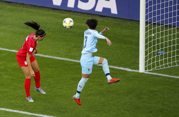 United States' Alex Morgan, left, heads the ball past Thailand's Natthakarn Chinwong to score her team's first goal during the Women's World Cup Group
