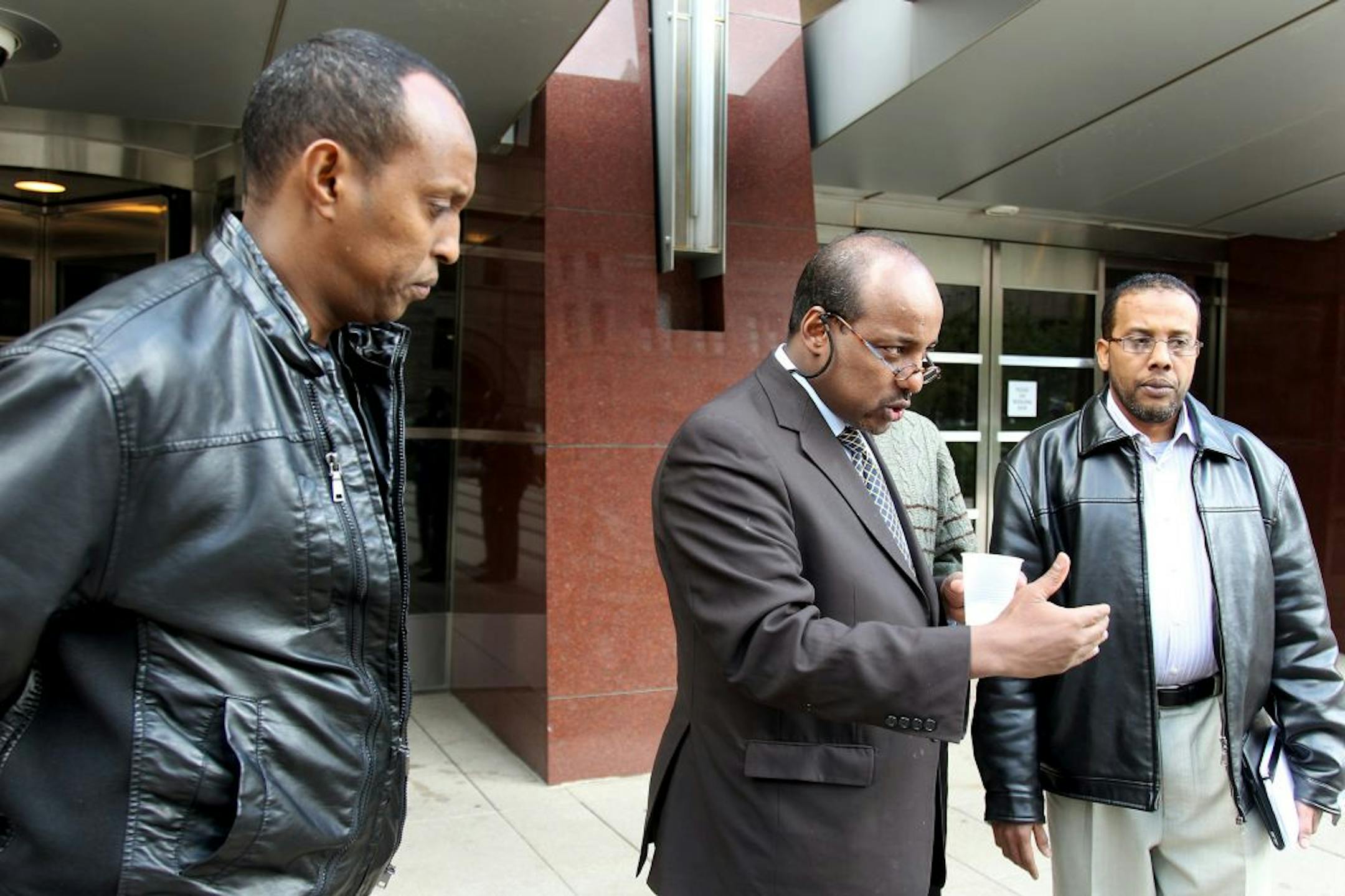 Omar Jamal, center, a spokesman for the family of defendant Mahamud Said Omar, spoke to the press alongside Omar's brothers Hussein Sharif, left, and Abdulahi Sharif on Wednesday.